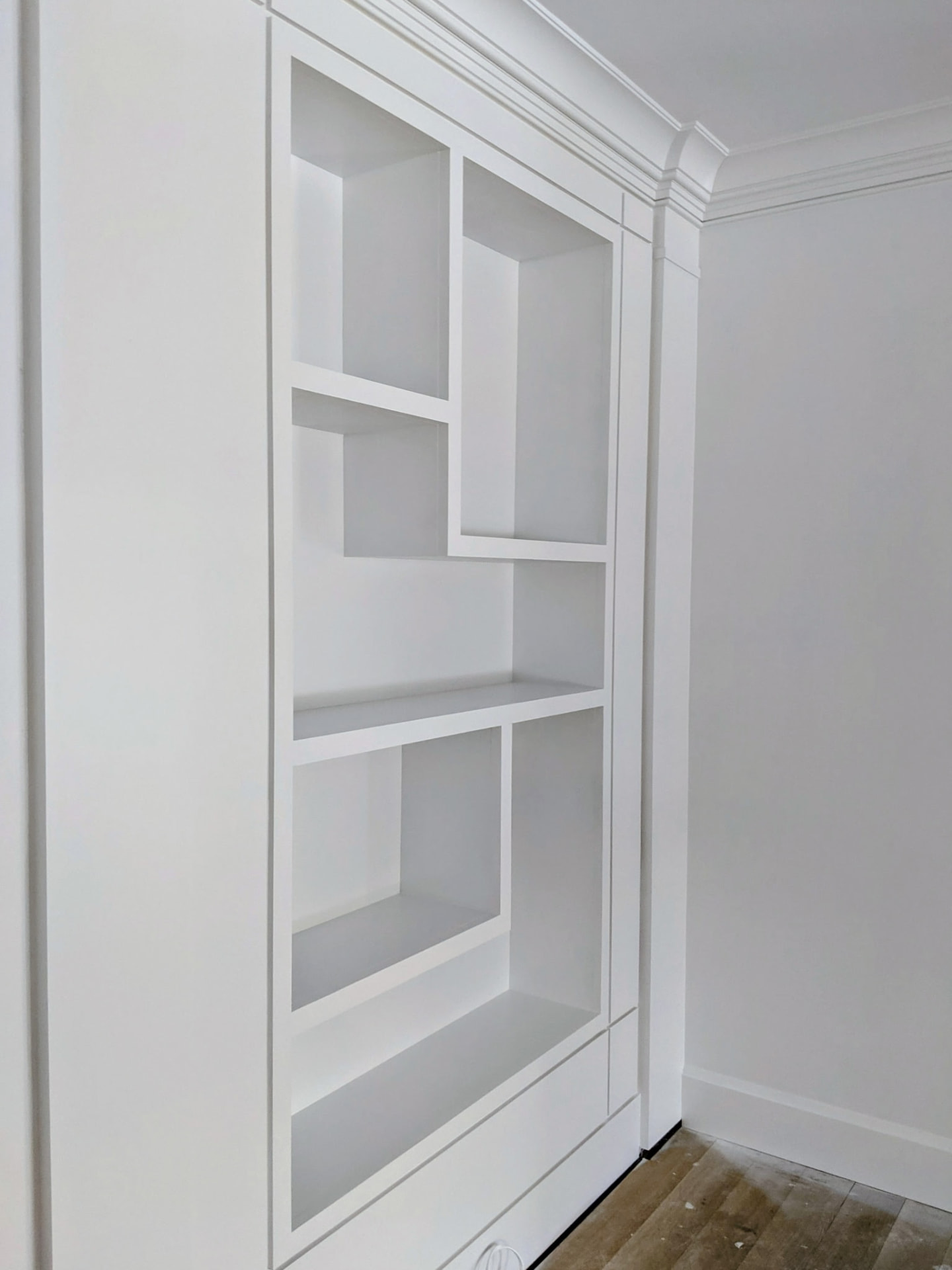 Close angled view of the painted right-hand asymmetric shelving unit in a Greenwich CT living room