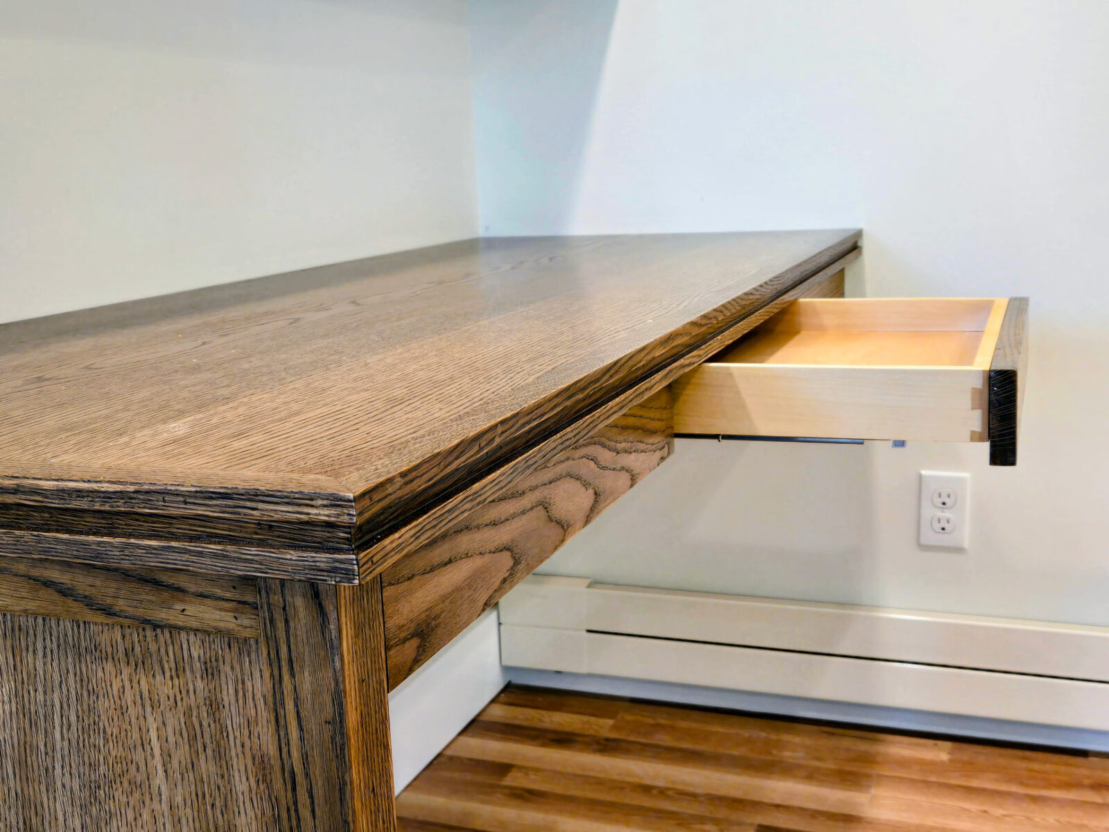 Close-up of custom oak desk top and open pull-out drawer in a Ridgefield CT home office