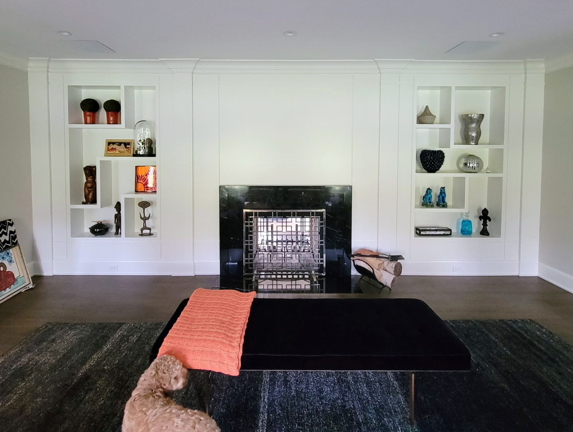 Custom asymmetric built-in shelving flanking a fireplace in a finished Greenwich CT living room by Glissmann Construction