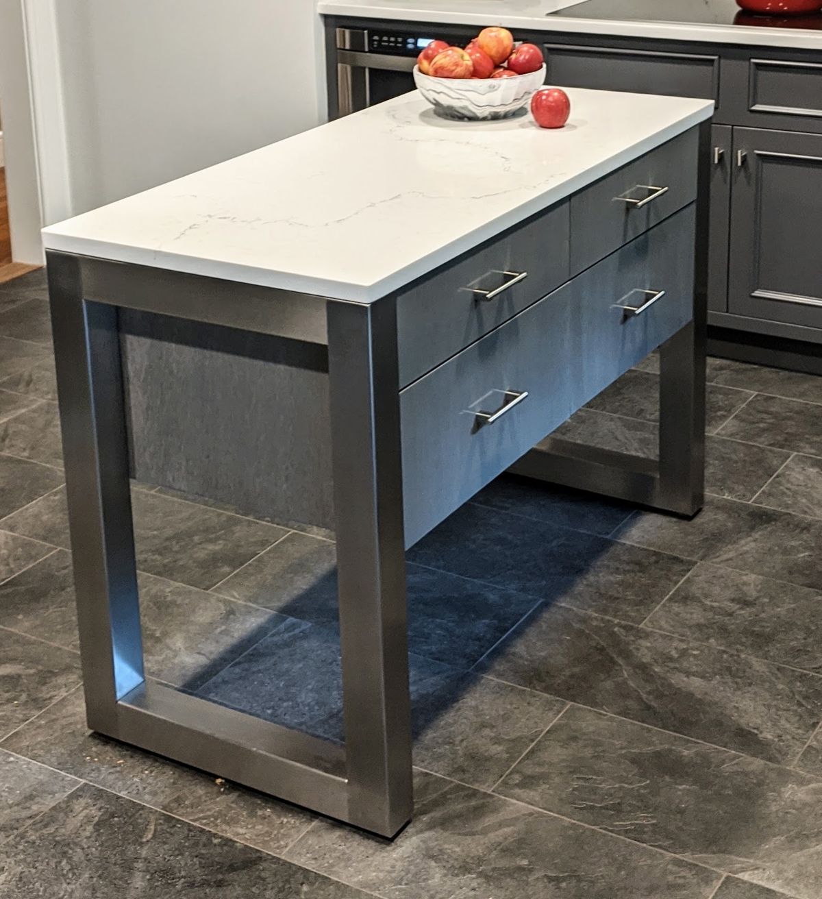 Finished custom kitchen island with white stone countertop, storage drawers and metal base in Bedford, NY