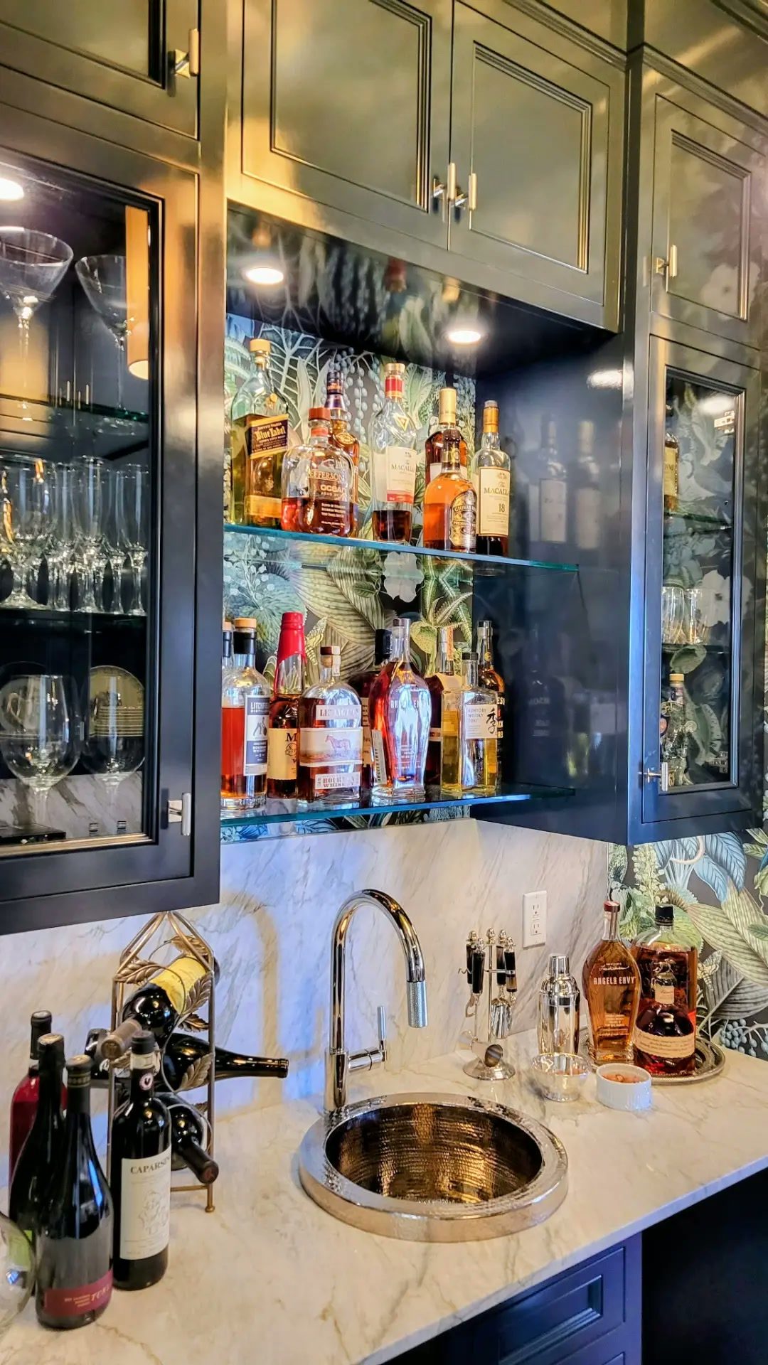 Custom butler's pantry and home bar in Ridgefield CT — finished dark cabinetry with glass-front display cabinets, illuminated glass shelving, a stone countertop and an integrated bar sink