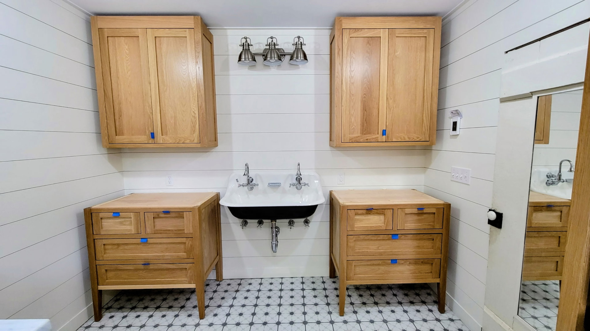 Oak bathroom vanities flanking a black trough sink in a Ridgefield, CT bathroom