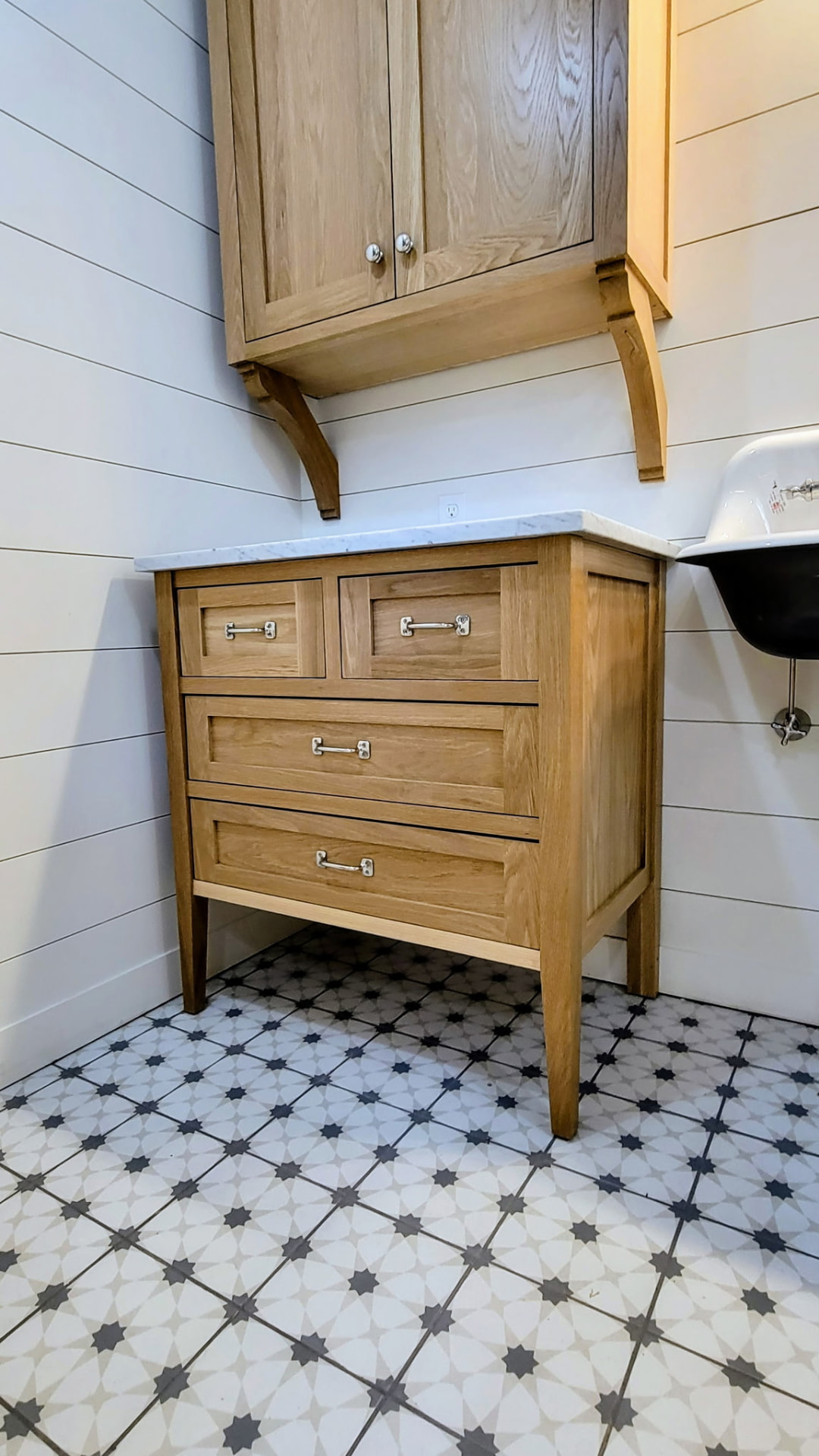 Oak bathroom vanity with marble top and corbelled wall cabinet built by Glissmann Construction in Ridgefield, CT