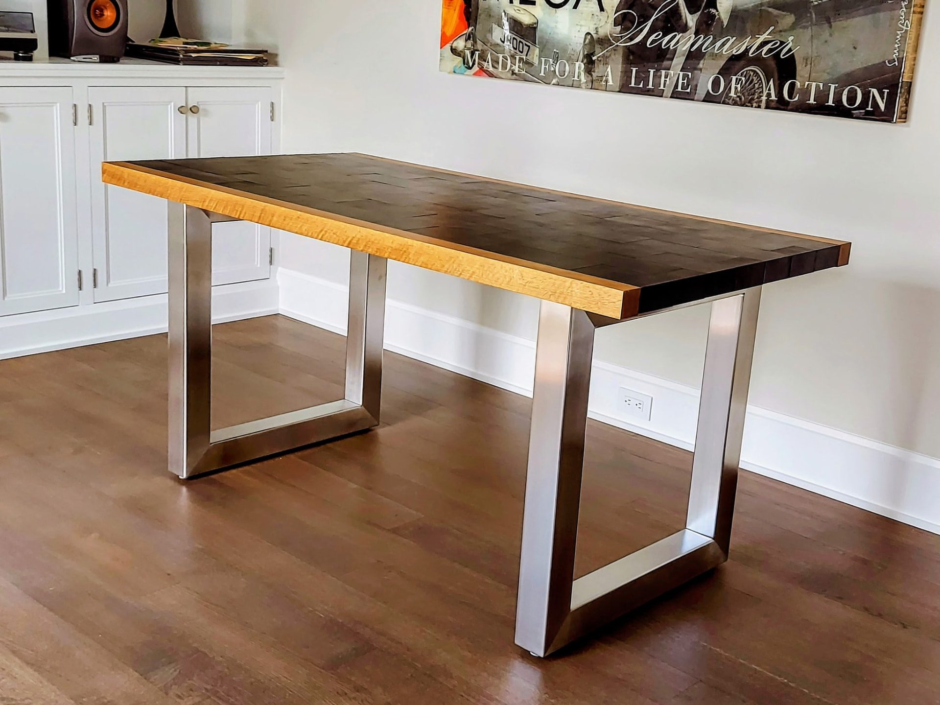 Custom white oak leather and stainless steel desk in Greenwich CT by Glissmann Construction — figured white oak tabletop with a dark leather inset and brushed stainless steel sled legs